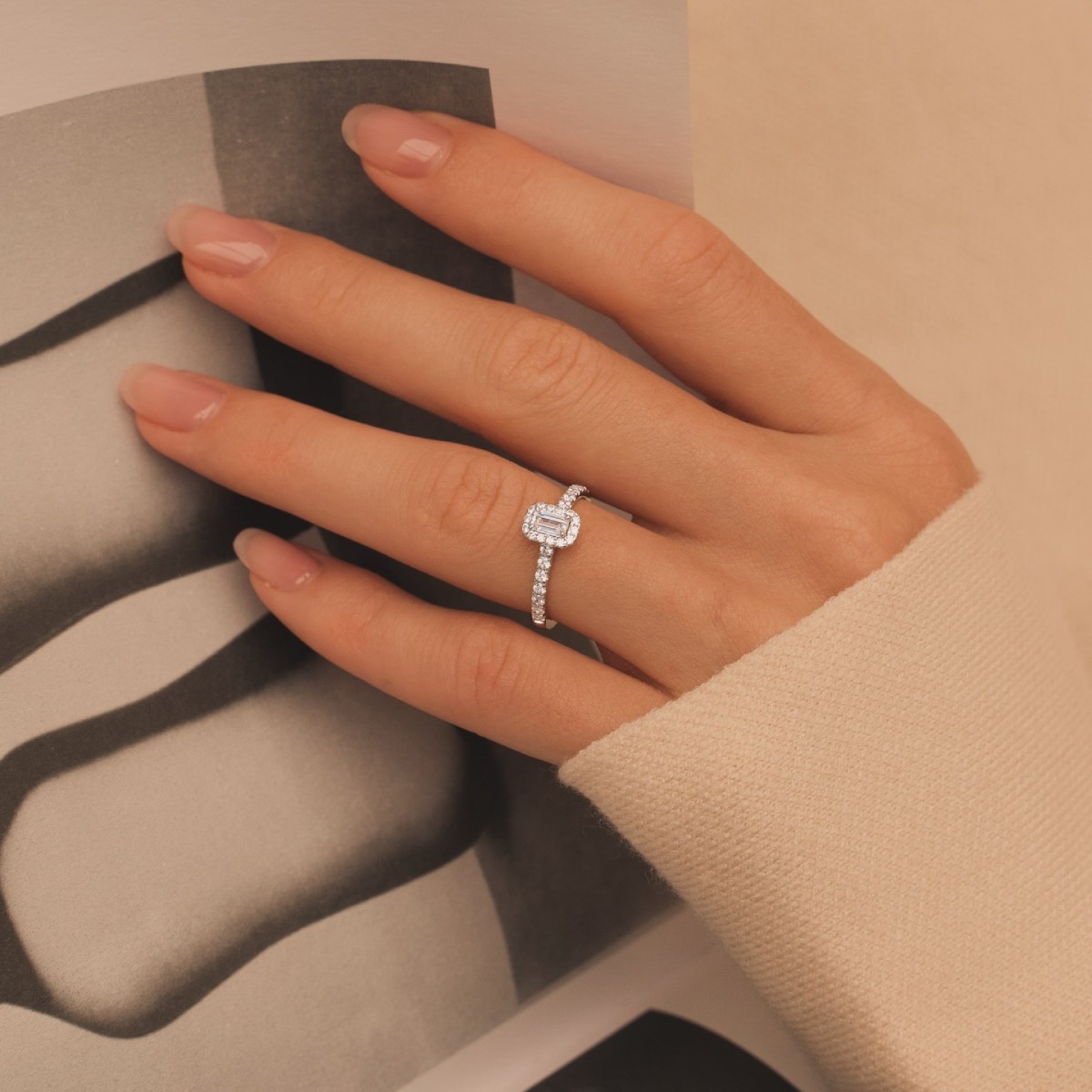 Main féminine portant une bague de fiançailles en or 18K avec diamant sur l’annulaire gauche, illustrant la manière traditionnelle de porter une bague de fiançailles.